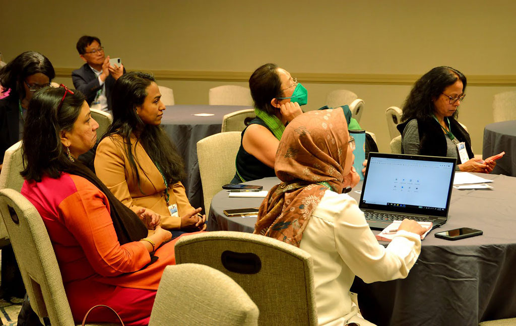 Attendees participate in a discussion during the "The Golden Compass Onward: Securing success of foreign-born women faculty in their career, leadership, and life in the United States" roundtable session during the AAG 2023 annual meeting.